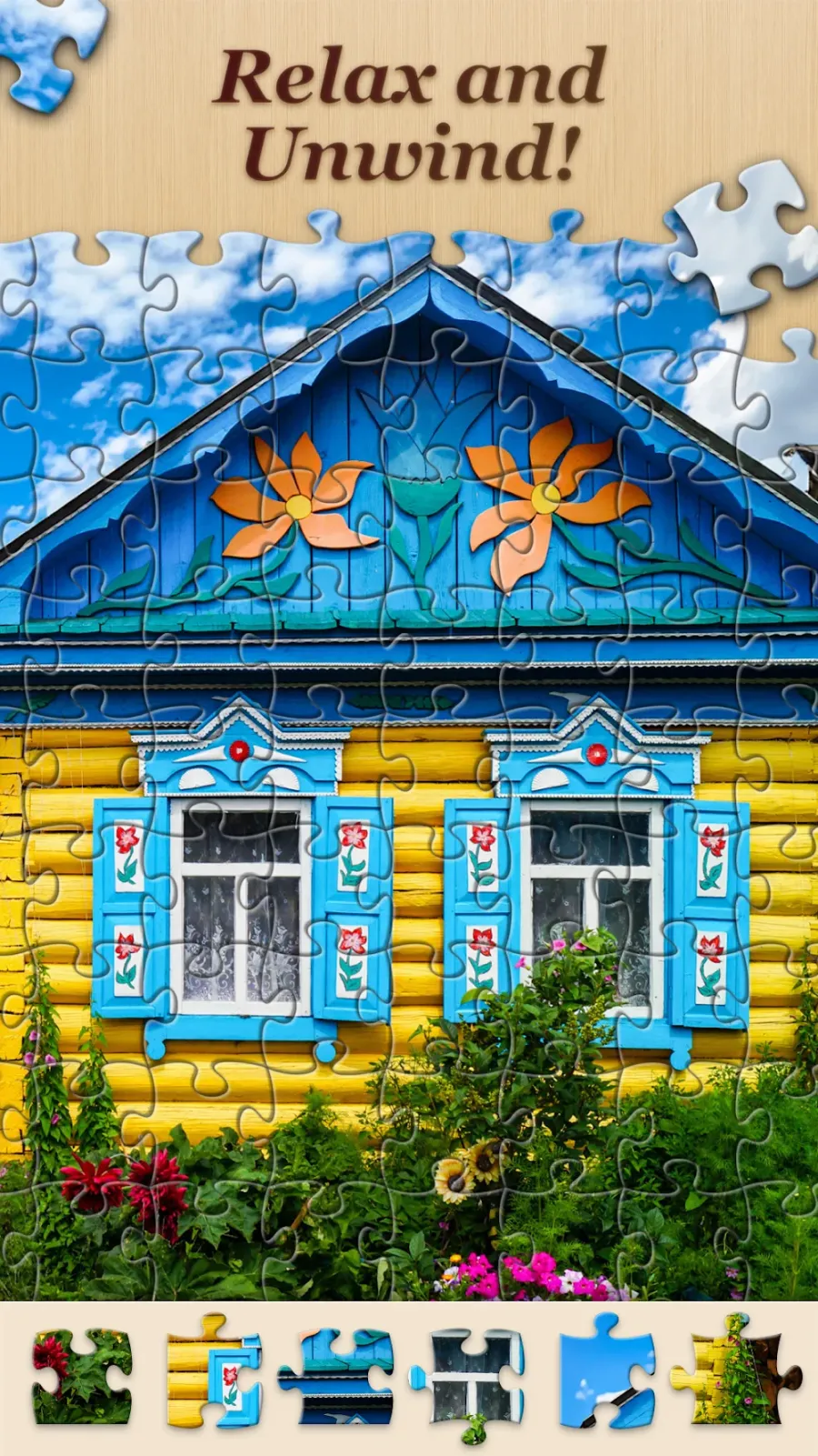 Jigsawscapes kirakós játék androidra: faház képe félig kirakva, alul a darabok sorával